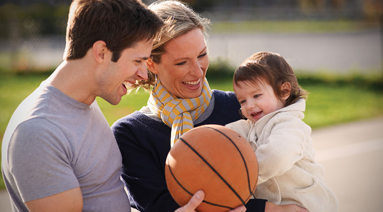 Family of three holding basketball