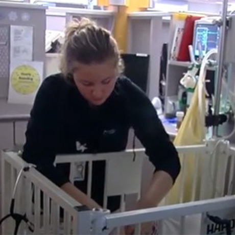 Nurse tends to newborn in crib