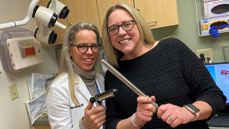 Janice Rafferty, MD, and Q102's Jennifer Fritsch holding surgical instruments