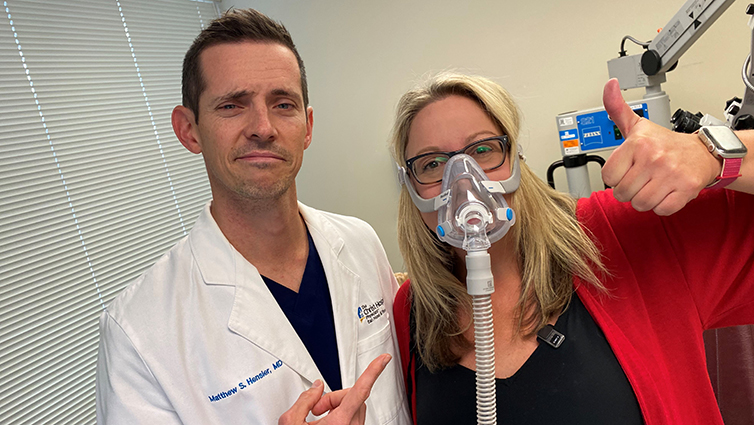 Dr. Matthew Hensler with Q102's Jennifer Fritsch wearing CPAP mask
