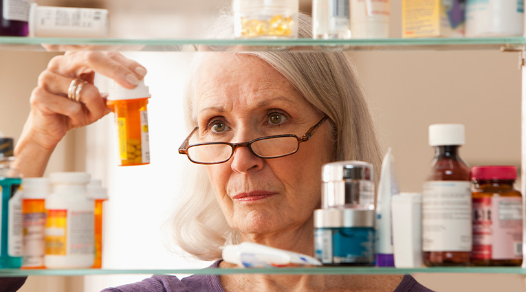 Woman looking in medicine cabinet