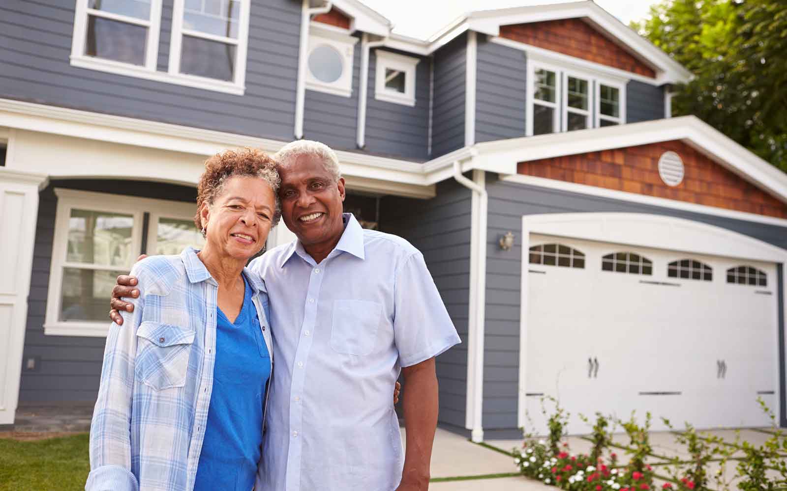 A couple standing in front of their house ready to enjoy their empty nest