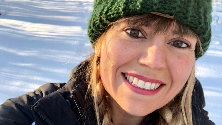 Former B105 radio personality Amanda Valentine, wearing a winter hat and coat outside in the snow.