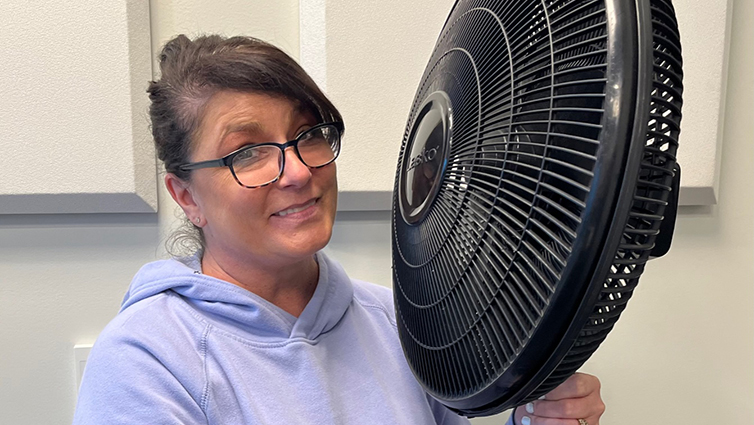 B105 radio personality Chelsie holding a fan for her blog about menopause symptoms.