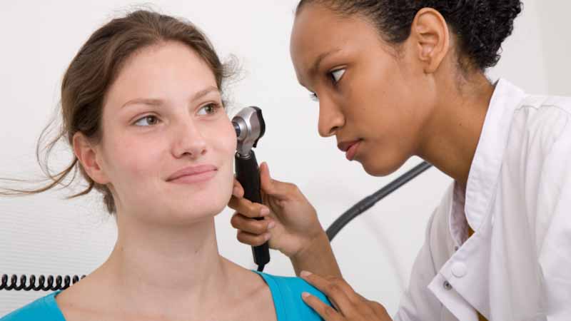 Women getting her ear checked by her doctor.