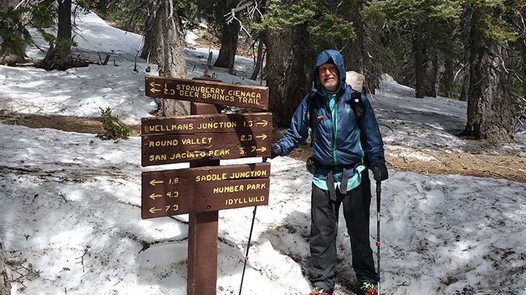 Patient Mike O'Connor hiking through snow, wearing hiking gear.