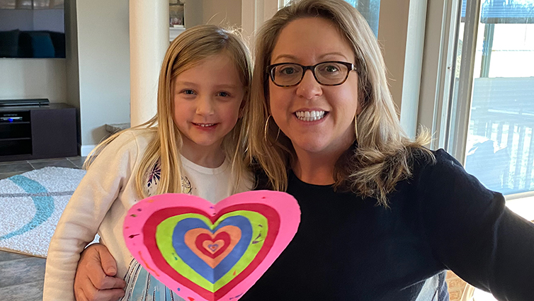 Q102 radio personality Jennifer Fritsch and her daughter holding up a paper heart for her blog about pregnancy and heart health.