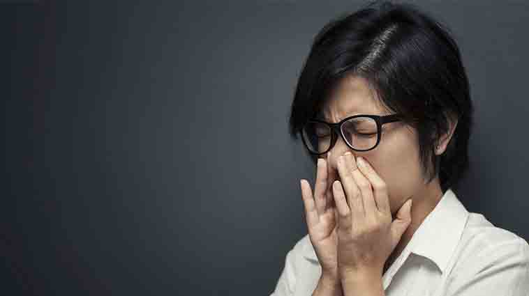 Woman holding her face with sinus pain