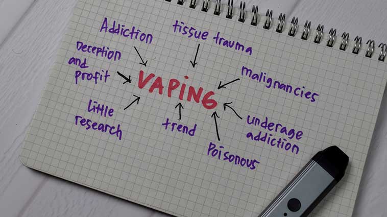 Notepad with charge noting the dangerous effects vaping has on your health.