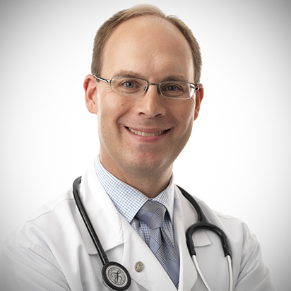 Thomas Lamarre, MD, in a white lab coat with stethoscope.