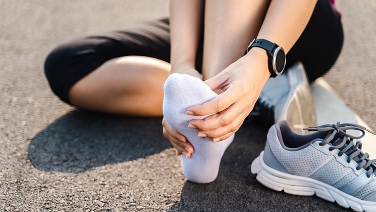 Person takes shoe off to massage foot