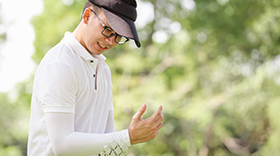 Asian man holding sore elbow