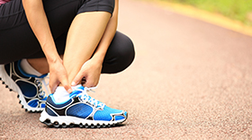 Person running on track hurt sprained ankle