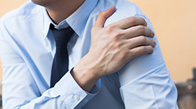 man in shirt with shoulder pain