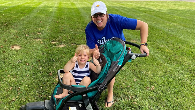 Q102 radio personality Jennifer Fritsch with her daughter in a stroller on a walk, a low-impact exercise.