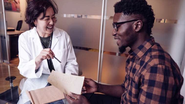 Asian female physician talking to African American male patient about men's health issues.