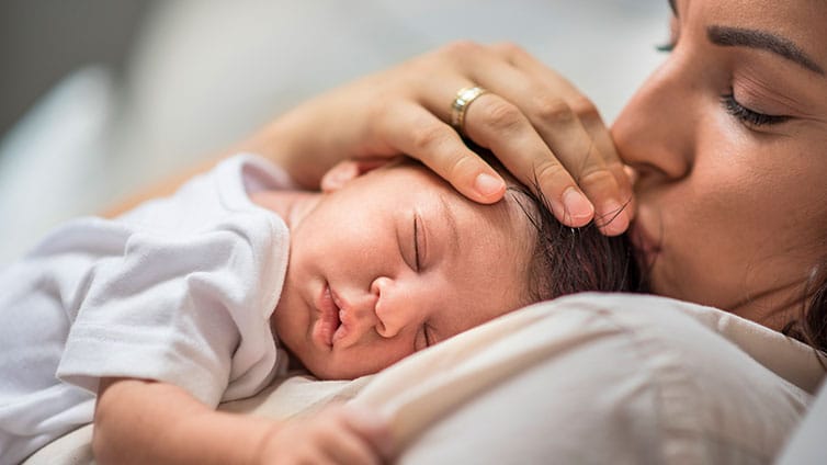 Sleepy baby rests on mother's chest
