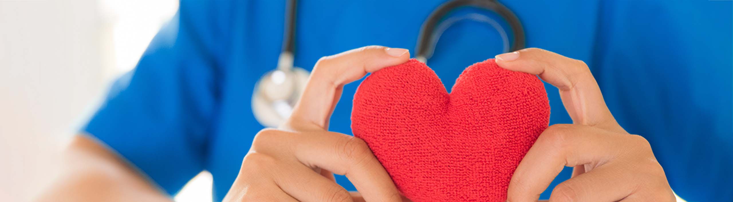 Medical worker holding knitted heart